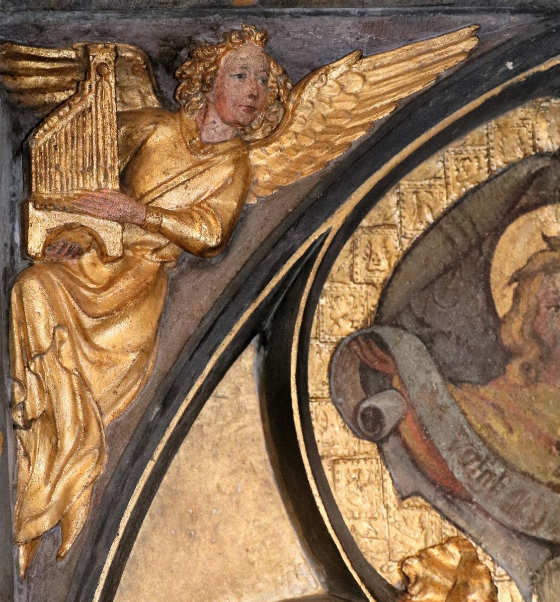 Détail d'un ange jouant de la harpe, représentant une peinture d'écoinçon restaurée. 