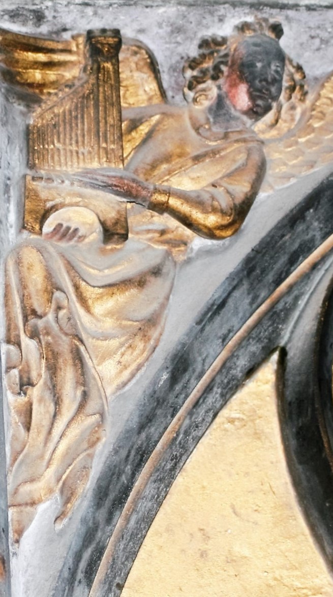 Détail d'un ange jouant de la harpe, représentant une peinture d'écoinçon avant sa restauration. 