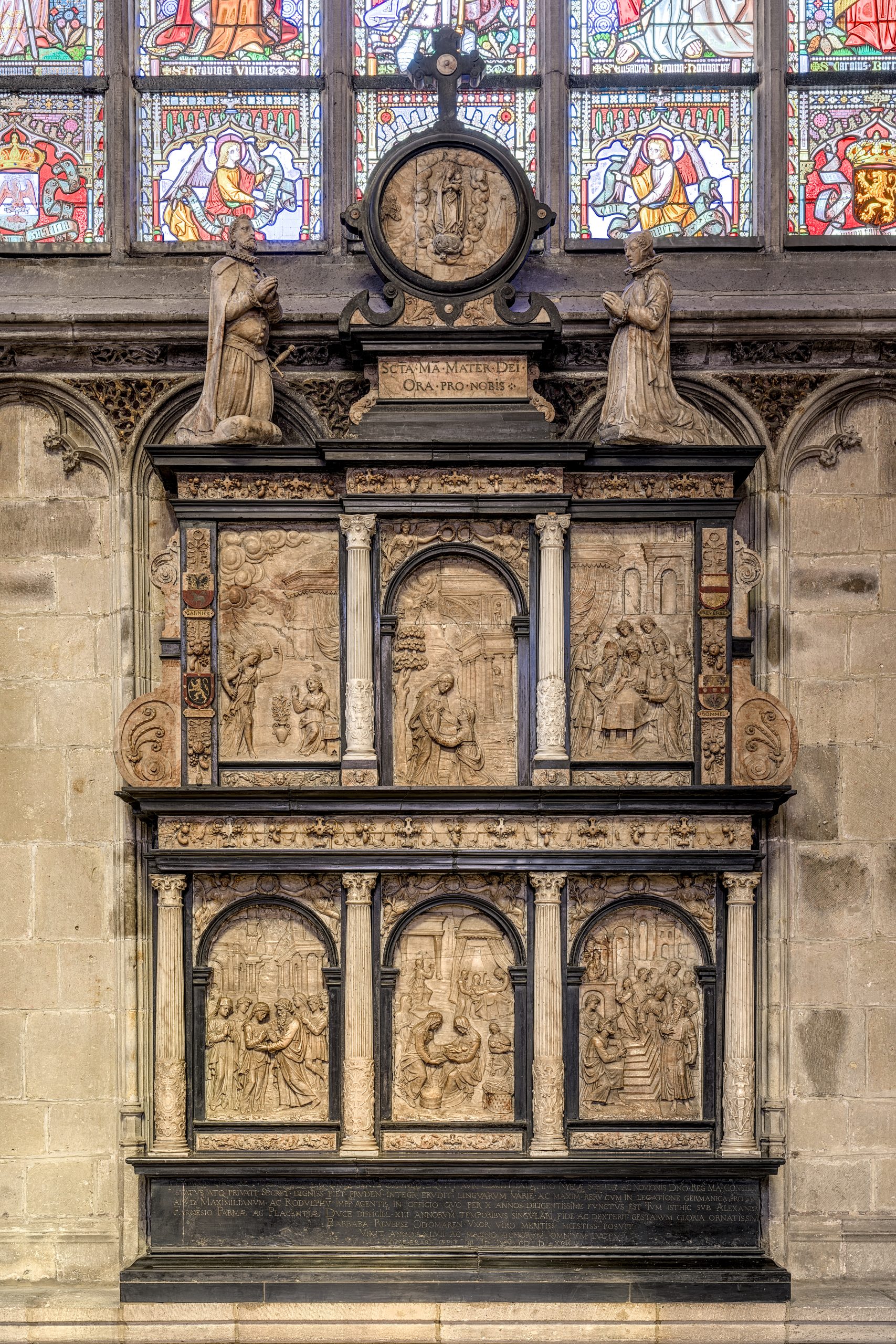 Retable en pierre sculpté avec plusieurs scènes religieuses, encadré par des colonnes et surmonté de statues, à l'intérieur de l'église Notre-Dame au Sablon.